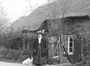 Jane Cook standing in front of her cottage